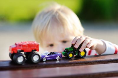 Toddler boy playing with toy cars 