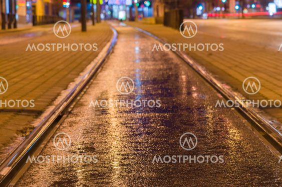 Tram rail track wet and shiny by night lights