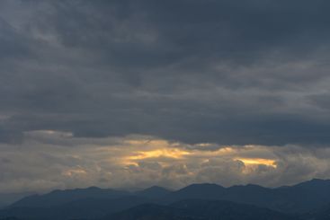 Majestic mountain landscape under a dramatic sky at dusk...