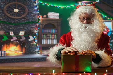 Saint Nicholas decorates many presents with ribbons and...