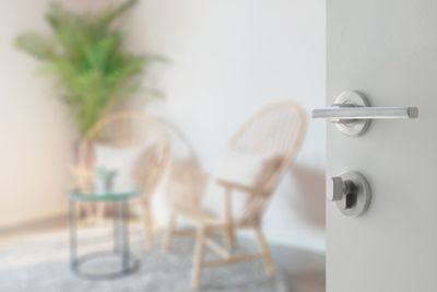 opened white door to living room interior with wooden...