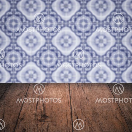 Wood table top and blur vintage ceramic tile pattern wall
