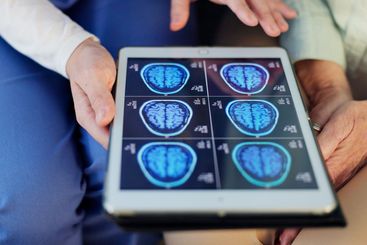 Hands, doctor and patient with tablet, brain scan and...