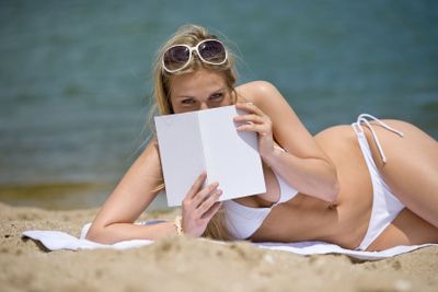 Blond woman relax on beach with book