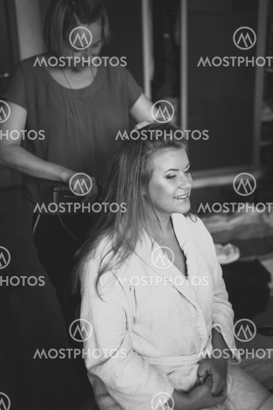 portrait of hairstylist preparing happy bride to wedding...