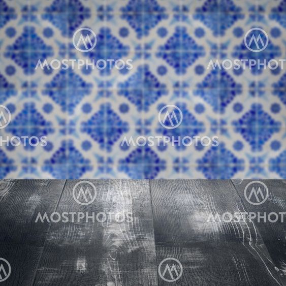 Wood table top and blur vintage ceramic tile pattern wall