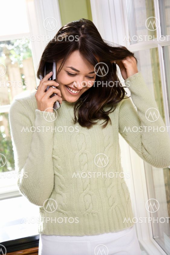 Woman on cellphone smiling.