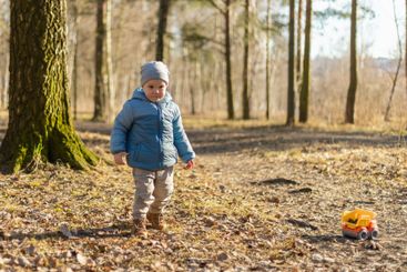 Happy baby child outdoor. Little toddler boy with toy...