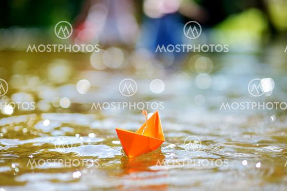 Orange paper boat with a white flag