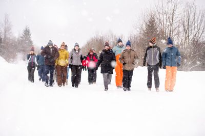 group of young people walking through beautiful winter...