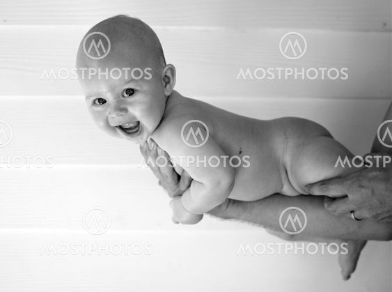 Black and white baby lies on arm
