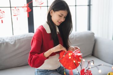 Asian Woman decorated house for Chinese New Year...