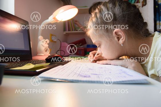 The girl is studying at home remotely while in her room