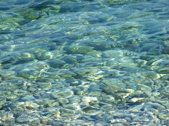 pebbles under a blue surface of sea water