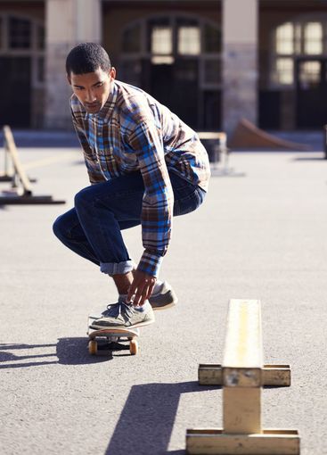 Man, skateboard and riding at urban skatepark, sports...