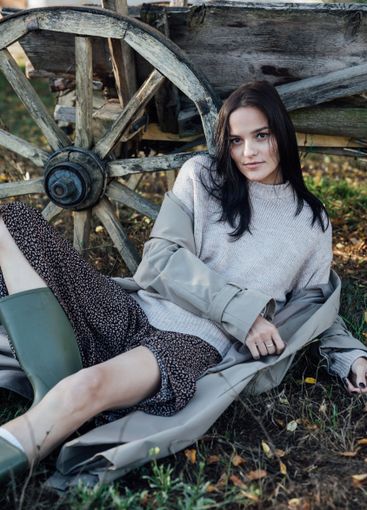 Beautiful brunette woman in coat at wooden cart