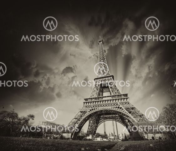 Wonderful view of Eiffel Tower in Paris. La Tour Eiffel with sunset sky and meadows