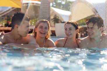 Cute boys and girls in swimsuits and sunglasses are...