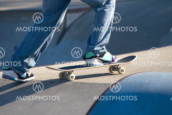 Skateboarder foot pushing skateboard with torn shoes