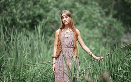 beautiful hippie girl standing on a wooden bridge in the...