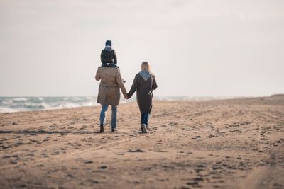 parents and son walking on seashore 