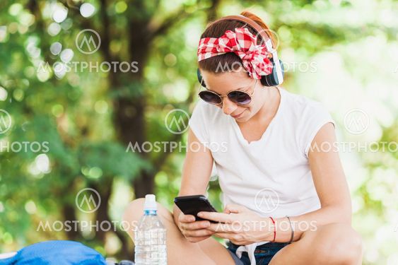 Young woman listening to the music on the smartphone