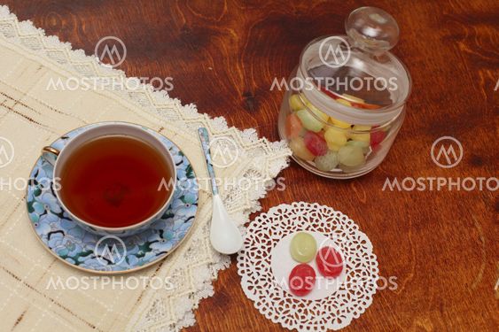 Tea with coloured sugar candies in a glass can