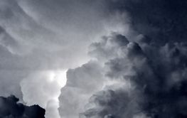 Dark blue and grey clouds with blinking thunders before...