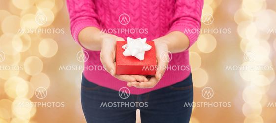 close up of woman in pink sweater holding gift box