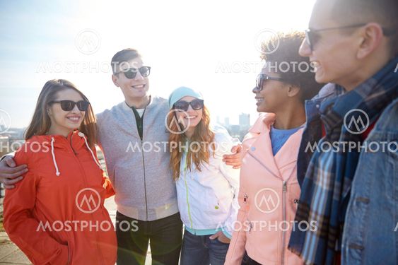 happy teenage friends in shades talking on street