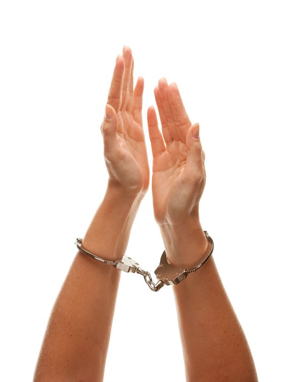 Handcuffed Woman Raising Hands in Air on White
