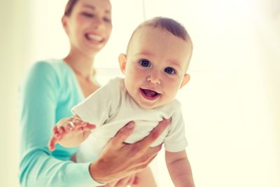 happy young mother with little baby at home