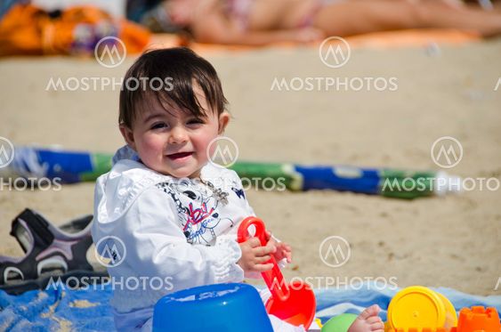 Baby Girl relaxing and playing on a Beach Towel