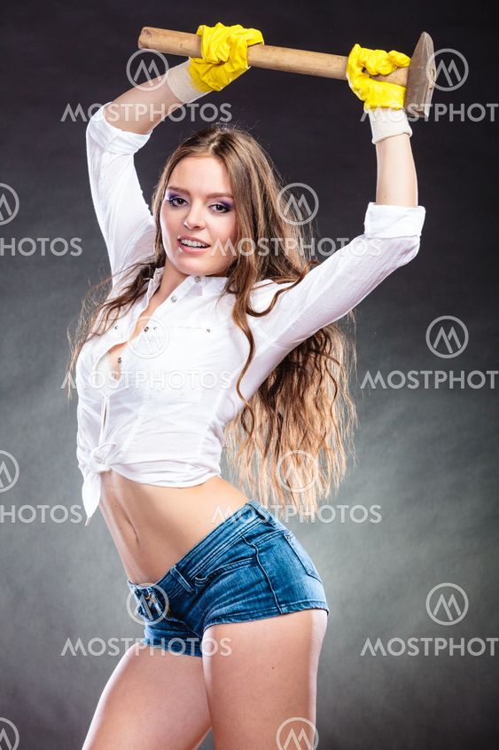 Sexy alluring woman holding hammer. Feminism.