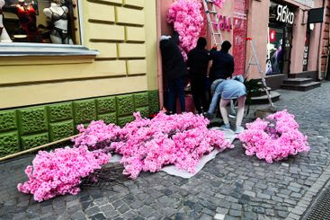 Team preparing decorative floral installation on store...
