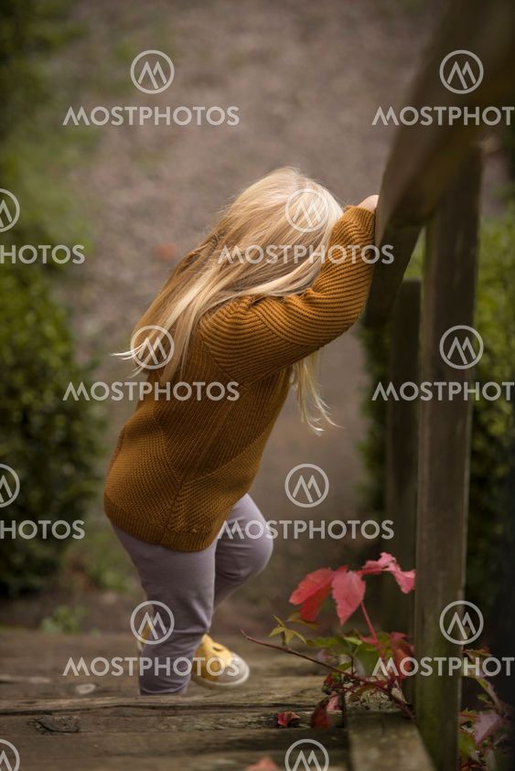 Liten flicka går nerför en trätrappa