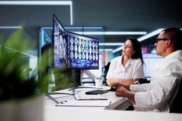 Doctors In Clinic Looking At Brain MRI Scan