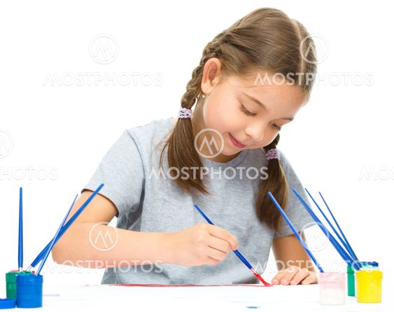 Little girl is painting with gouache