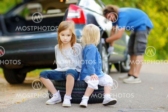 Happy family changing a car wheel
