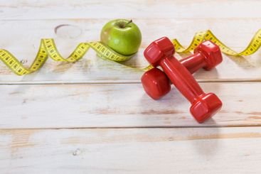 Fitness concept with dumbbells and measuring tape