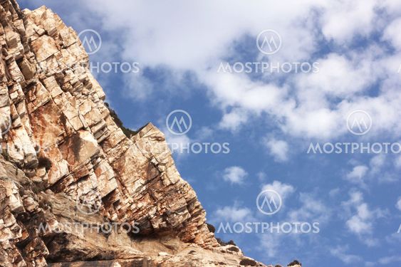 Big rock under blue clouded sky