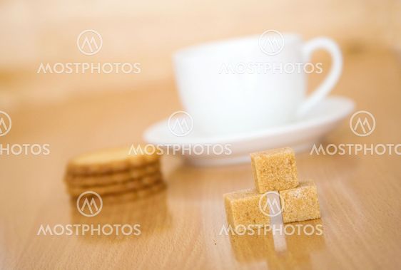 Cup of tea or coffee, sugar and biscuits. Focus on the sugar