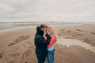 beautiful happy young couple hugging on seashore in Riga,...