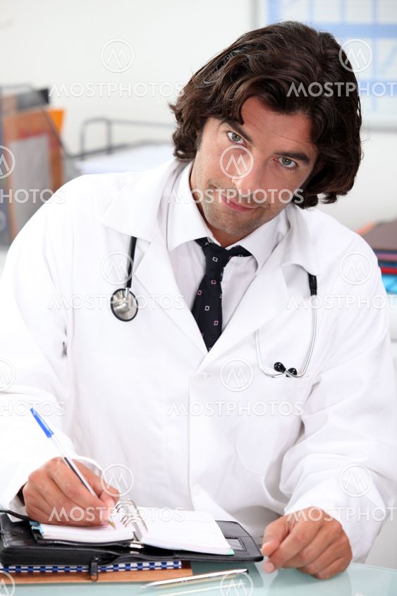 Handsome hospital doctor writing in a personal organizer