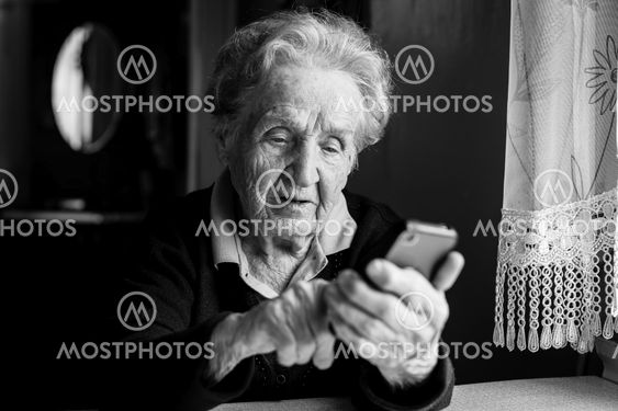 Elderly woman typing on the smartphone.