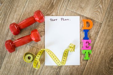 Fitness concept with dumbbells and measuring tape