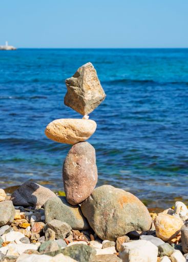 Carefully balanced stack of stones on a rocky beach with...