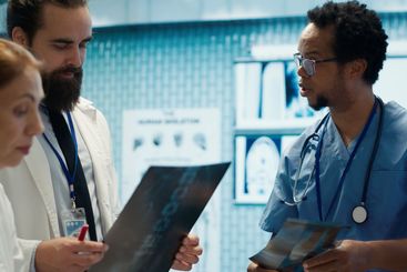 Physicians and radiologists analyzing x ray scans to...