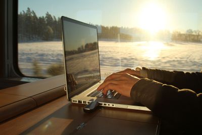 Man med laptop på tågresa