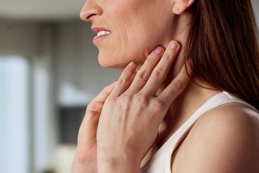 Beautiful young woman experiencing thyroid gland pain